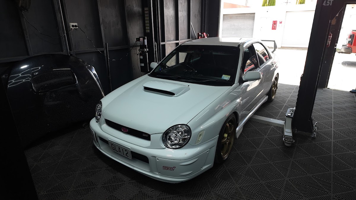 White Subaru WRX STI on the hoist inside Kinkz Motors